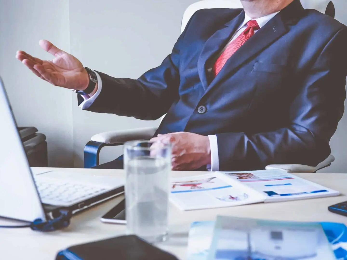 pexels-photo-288477 Man in suit gesturing during office meeting.