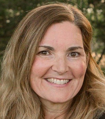 A woman with long hair smiling for the camera.