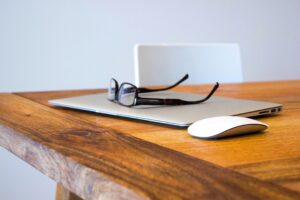 A pair of glasses sitting on top of a laptop.