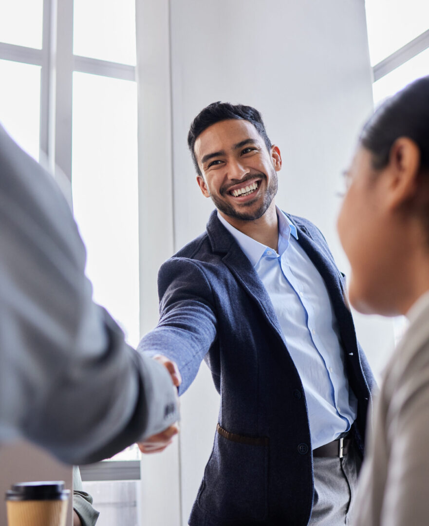 Shot of two business people shaking hands during a meeting Man smiling while shaking hands in office.