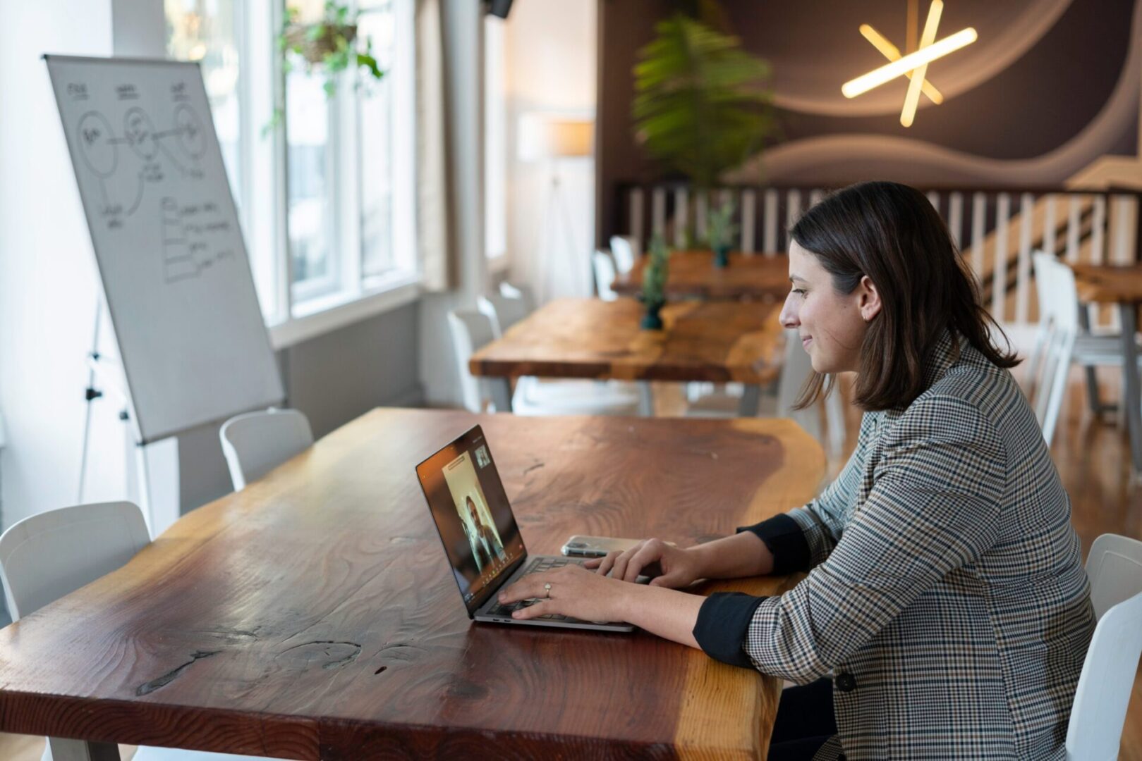Woman video conferencing on laptop in office.