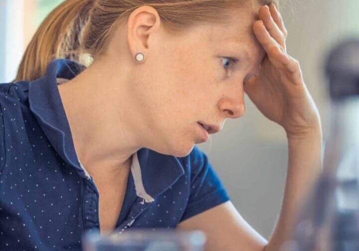 Woman stressed while using a laptop.